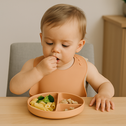 Baby eating pasta and broccoli from NARA Silicone Suction Plate in Neutral Beige