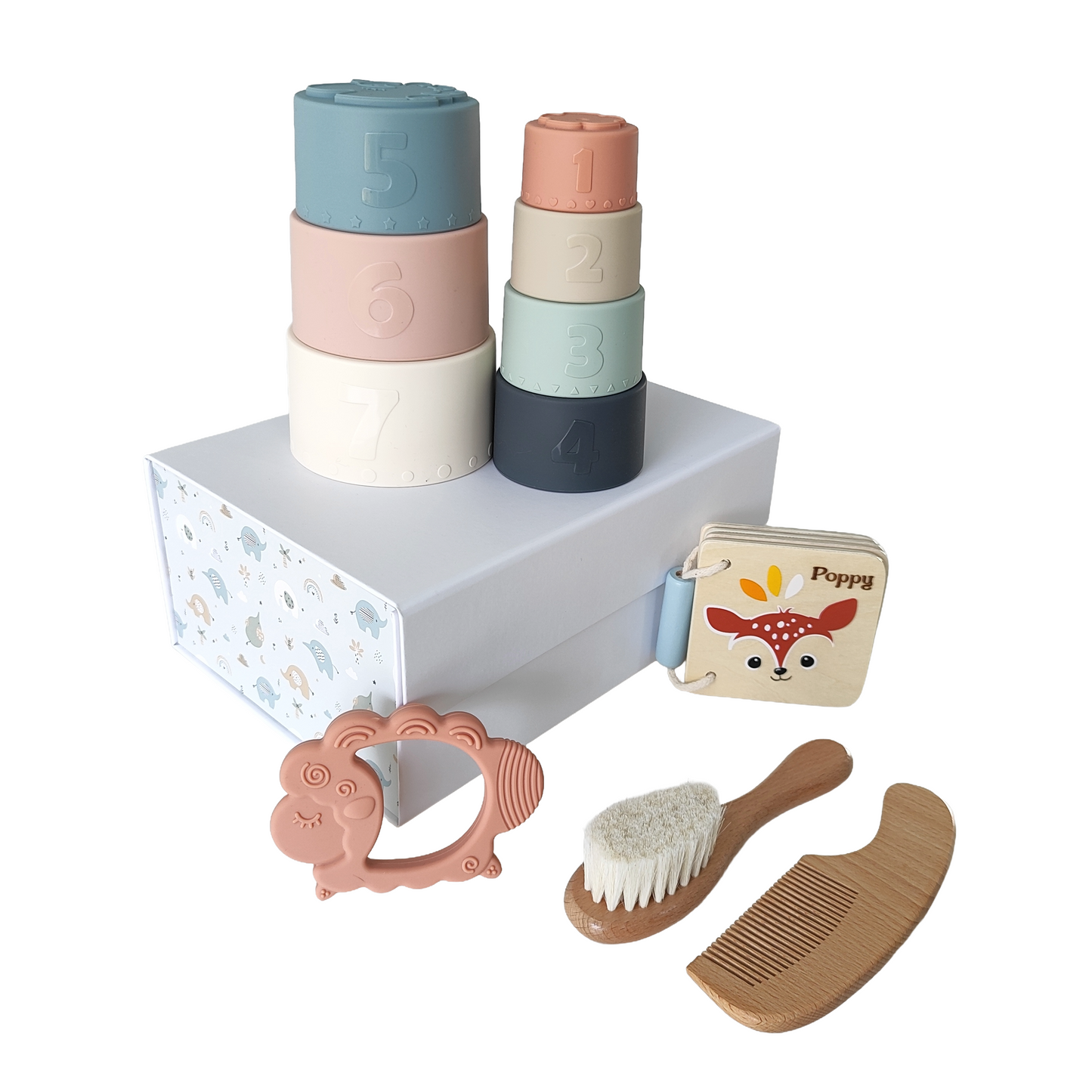 NARA × Speedy Monkey Stack, Read & Care Gift Set flatlay — seven silicone stacking cups, personalised Speedy Monkey Forest book engraved with Poppy, silicone lamb teether, and beechwood hairbrush and comb set, styled on a white display plinth