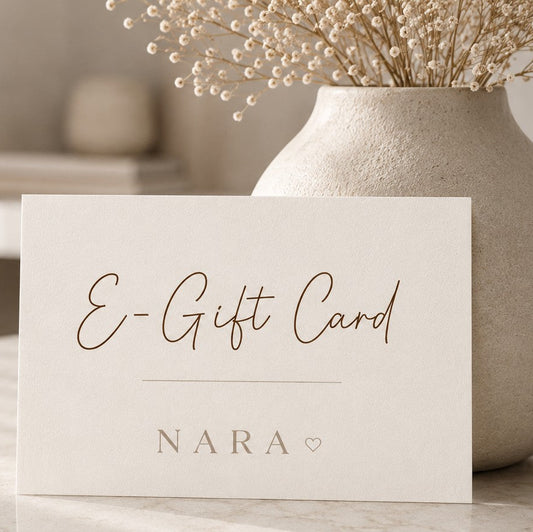 NARA E-Gift Card — cream card with script lettering propped against a textured ceramic vase with dried flowers