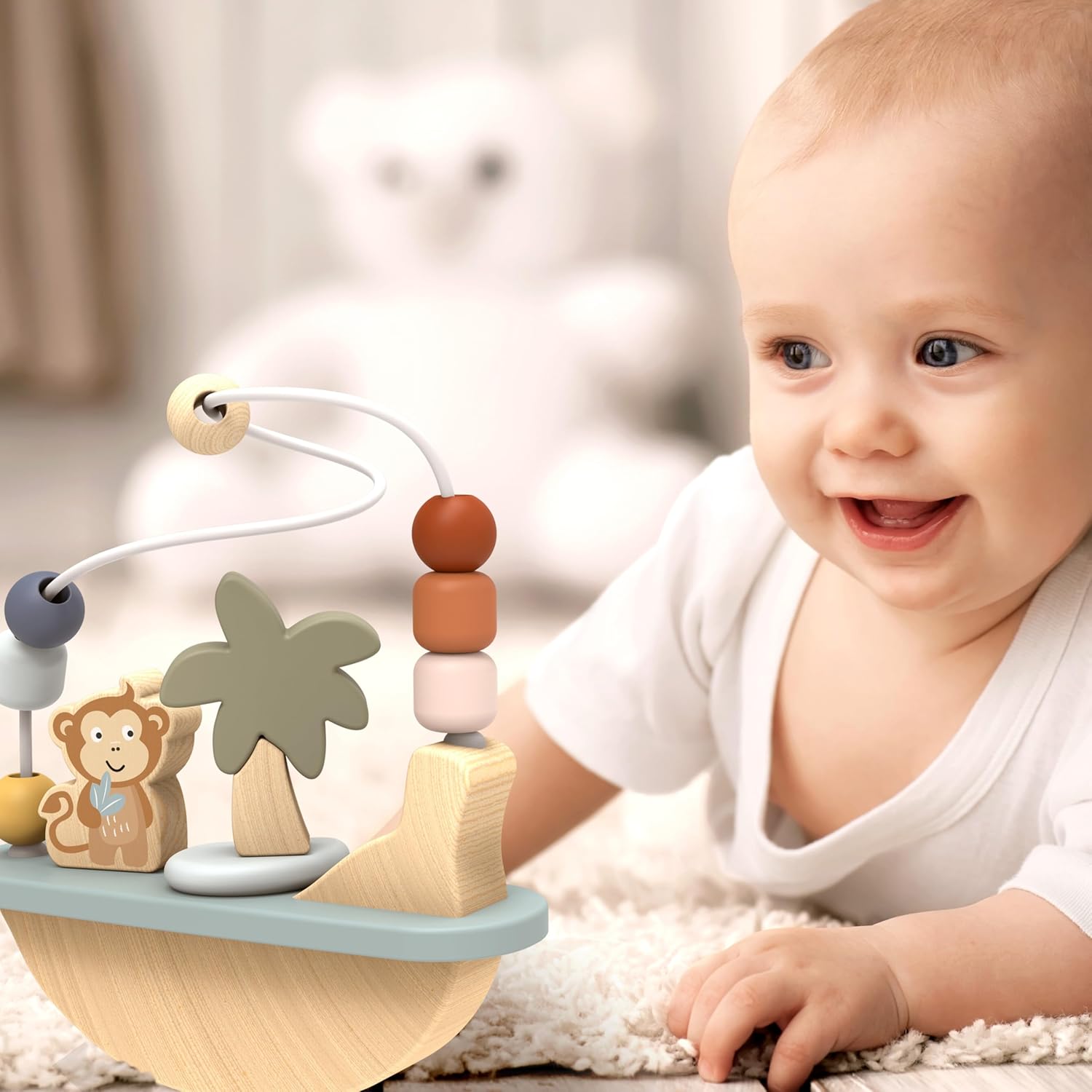 Baby smiling and reaching for a Speedy Monkey Rocking Beads Maze during tummy time. Wooden Montessori baby toy by NARA.