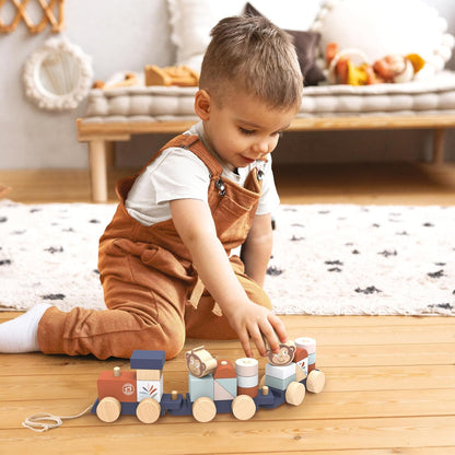 Toddler playing with the SPEEDY MONKEY Train Stacker on a wooden floor — stacking colourful wooden blocks onto the pull-along train. Personalised wooden toddler toy by NARA, ages 12 months and up.