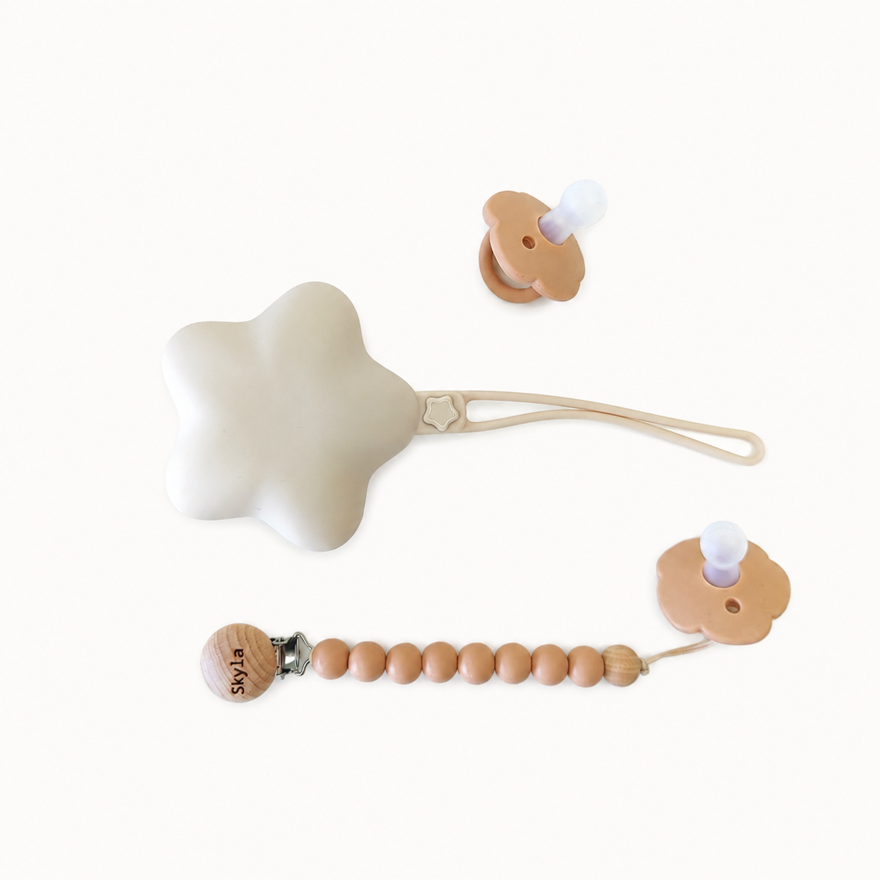 NARA Personalised Pacifier, Clip & Case Set in Neutral Beige — two silicone dummies, personalised wooden dummy clip and star-shaped silicone case, white background