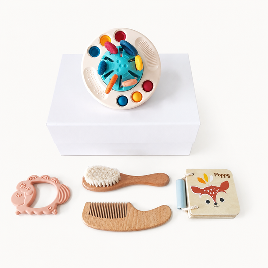 NARA × Speedy Monkey Sensory Play, Read & Care Gift Set flatlay — NARA Little UFO sensory toy on white gift box, with silicone lamb teether, beechwood hairbrush and comb, and personalised Speedy Monkey Forest book engraved with Poppy, cream background