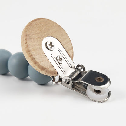Close-up of NARA personalised dummy clip — natural beechwood clasp with food-grade silicone beads in Ether