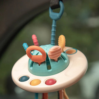 NARA UFO Pulling Toy clipped to a pram — close-up of textured silicone buttons and pull strings