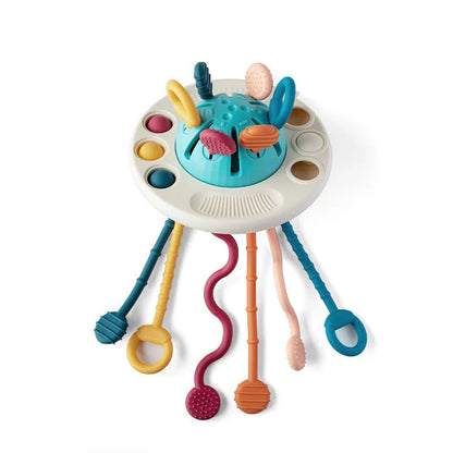 NARA UFO Pulling Toy — silicone sensory toy with six textured pull strings, pop-it buttons and pressable elements, white background